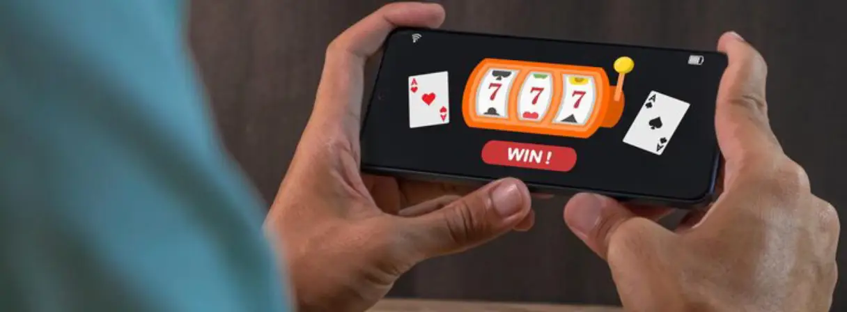 Two hands hold a smartphone displaying a slot machine game